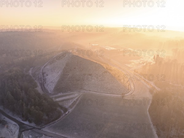 Hill in foggy landscape at sunrise, with surrounding roads and quiet atmosphere, future PV