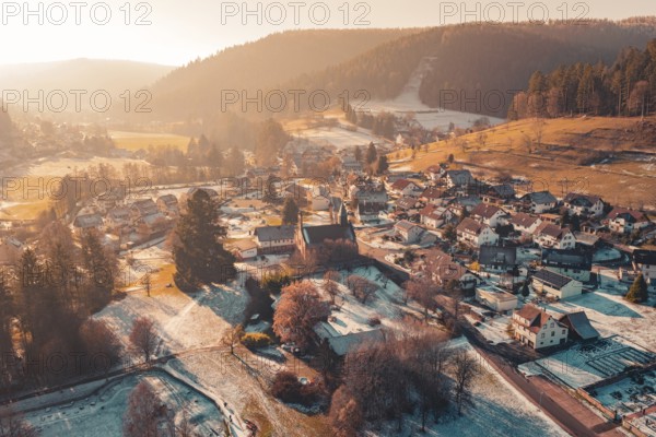Aerial view of a small village in winter nestled in a hilly landscape at sunset, Enzklösterle, Calw