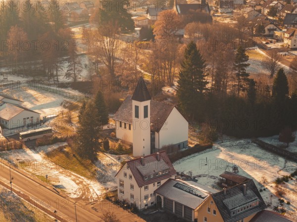 Close-up of a church in a small, snowy village surrounded by trees and a peaceful ambiance,