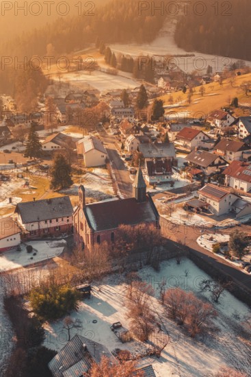 Snowy village with central church, warm sunlight bathes the surrounding area in golden tones,