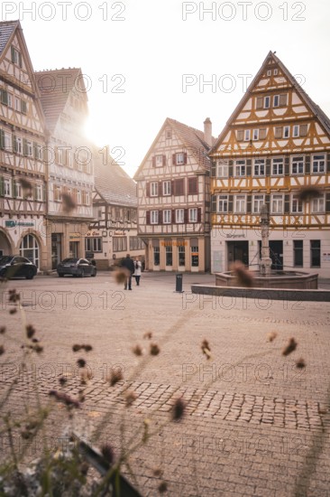 Historic old town with half-timbered houses and warm rays of sunshine on a quiet square,