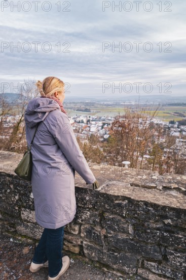 Woman in a coat looking out over a quiet winter landscape with a wide view, Herrenberg, Böblingen