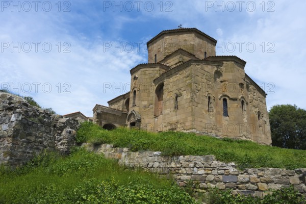 Stone church with grass-covered wall under blue sky, Javari Monastery, Jvari Monastery, Dzhwari