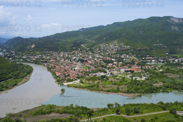Extensive landscape with river and city in the valley surrounded by mountains, confluence of Kura