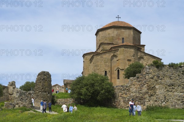 Old church and ruins in green landscape with people outdoors, Javari Monastery, Jvari Monastery,