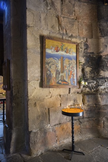 Religious icon on a stone wall with a burning candle in front of it, Javari Monastery, Dzhwari