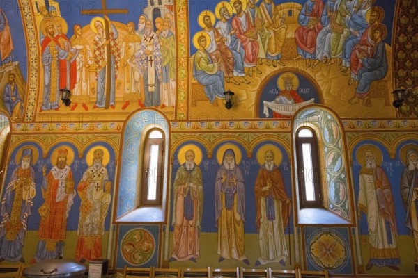 Orthodox church with glowing frescoes and saints, conveys a spiritual atmosphere, St. Barbara