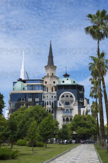 Historically inspired building with tower and palm trees, former registry office, now