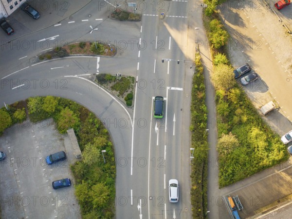 Aerial view of a street scene with cars at an intersection and green spaces, Deer E-Mobility
