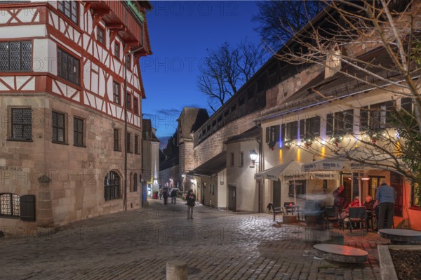 The old city wall with rampart, on the left the historic Dürerhaus, in evening lighting, Beim