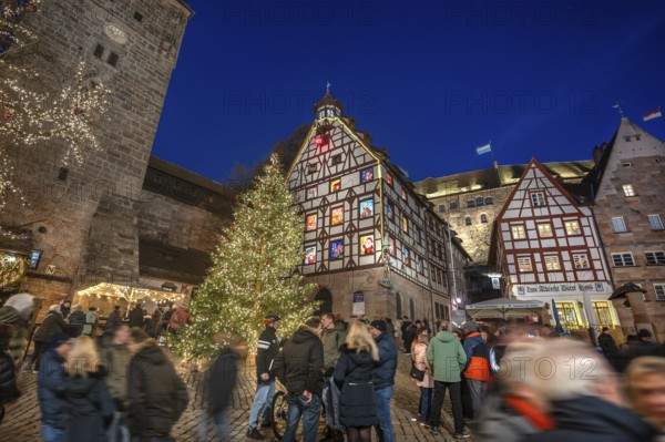 Illuminated Christmas tree with the historic Pilate House with advent calendar, in the evening