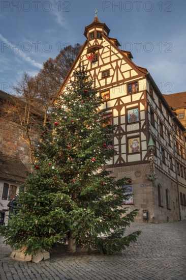 Decorated Christmas tree in front of the historic Pilate House with advent calendar in the evening