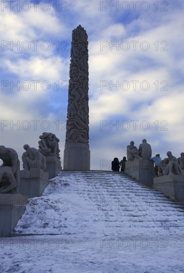 Large monolith surrounded by sculptures and a snowy staircase, Vigeland Sculpture Park Oslo Norway