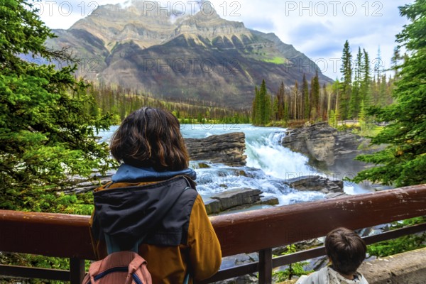 Tourists are enjoying the breathtaking view of athabasca falls, a powerful waterfall located in