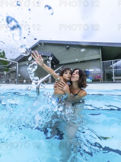 Mother and son are playing and splashing in a hot spring pool at miette hot springs in jasper