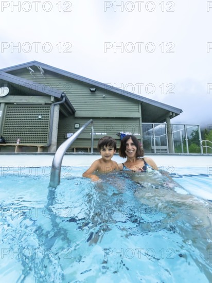 Mother and son are relaxing in a hot spring at miette hot springs in jasper national park, alberta,