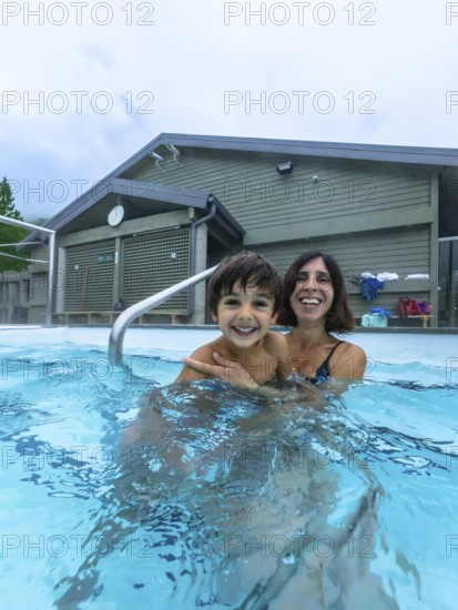 Mother and son are smiling and having fun while bathing in miette hot springs, located in the