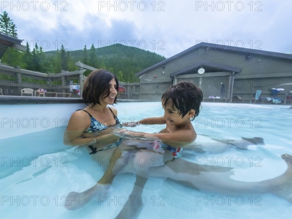 Mother and son are enjoying time together, playing in the warm, soothing waters of miette hot