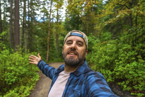 Happy hiker taking a selfie with open arms while walking the overlander falls trail in mount robson