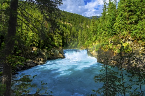 Majestic overlander falls cascading into the vibrant turquoise waters of the fraser river,