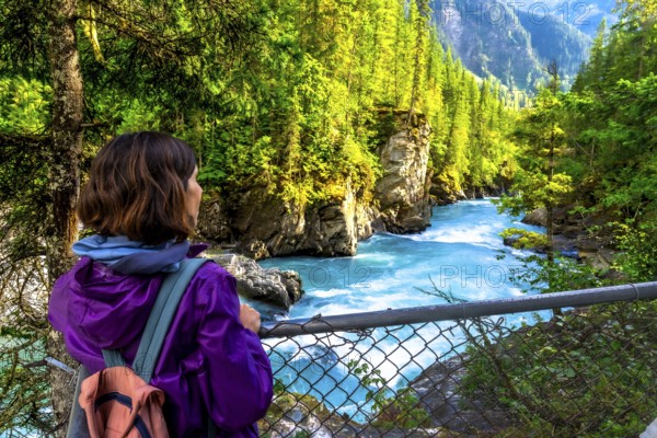 Female hiker enjoying the breathtaking turquoise waters of the fraser river cascading through the