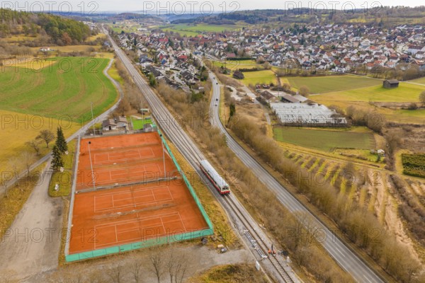 Train line and tennis courts on the outskirts of the city in hilly countryside, historic event,
