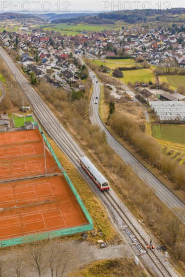 Train travels along tennis courts near a city, historic event, first test run with a passenger
