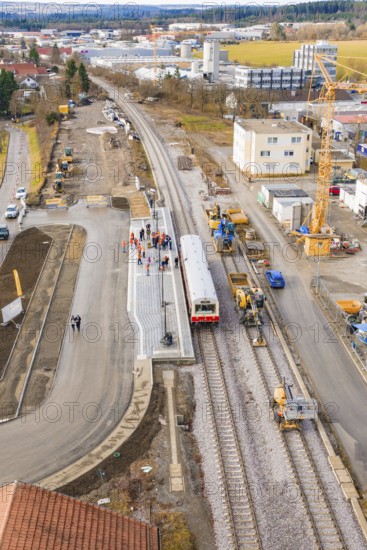 A construction site at a train station with construction work, cranes and a train. Residential