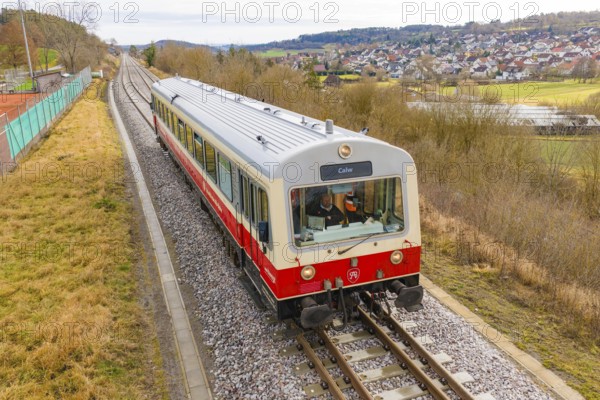 Train on the rails with a view of the city and countryside in the background, inscription 'Calw',
