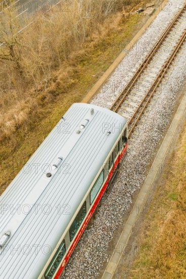 A train travels along the tracks through an autumn landscape. The sky is cloudy, historic event,