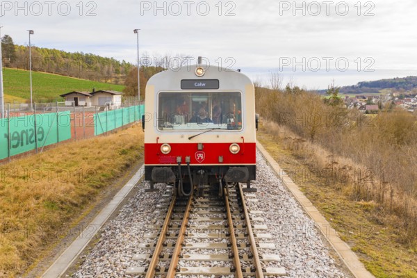 Front view of a train on the rails with landscape in the background, inscription 'Calw', historical