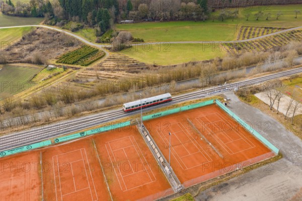 Aerial view of tennis courts next to a train line, historic event, first test run with a passenger