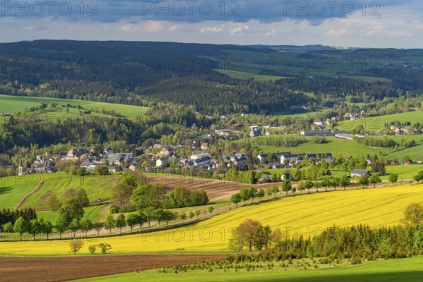 View from Schwartenberg over fields, forests, blooming rapeseed and the community of Neuhausen,