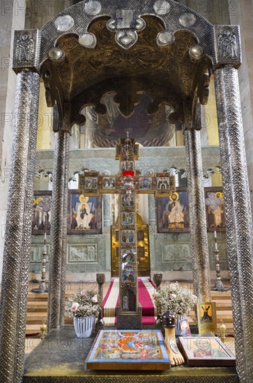 Richly decorated church altar with holy icons and cross surrounded by flowers, Svetitskhoveli
