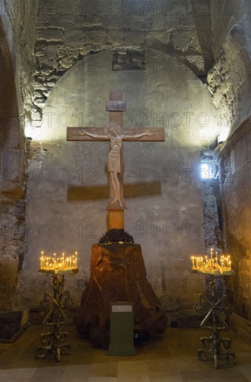 Interior of a church with a wooden cross and candlesticks on both sides, intimate religious