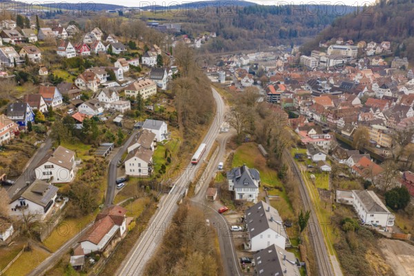 Aerial view of a village with railroad surrounded by hills and autumn trees, historic event, first