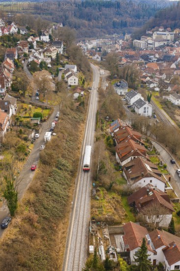 Suburb with railway line through hilly landscape with various residential buildings, historic