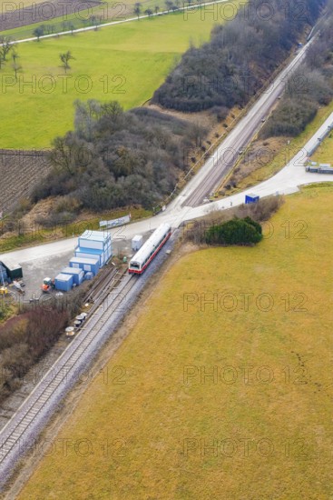 Train at a rural crossroads, surrounded by fields and some trees, northwestern perspective,