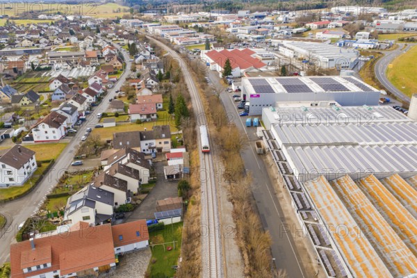 Cityscape with a train traveling through a mix of residential district and industrial area,
