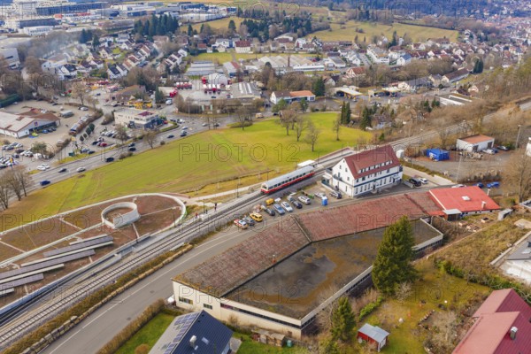 A train at a large train station, surrounded by residential buildings and roads, historic event,