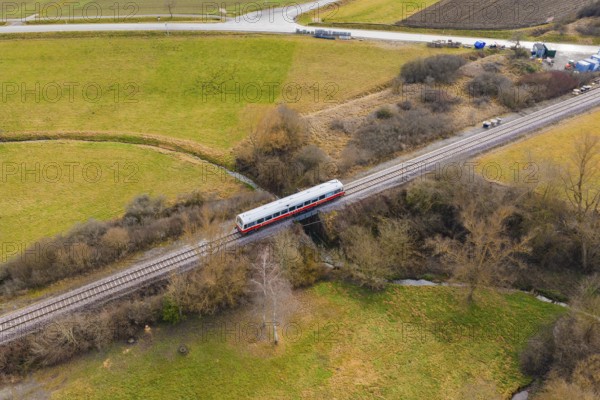 Train crosses a scenic bridge between winter fields and trees, historic event, first test run with