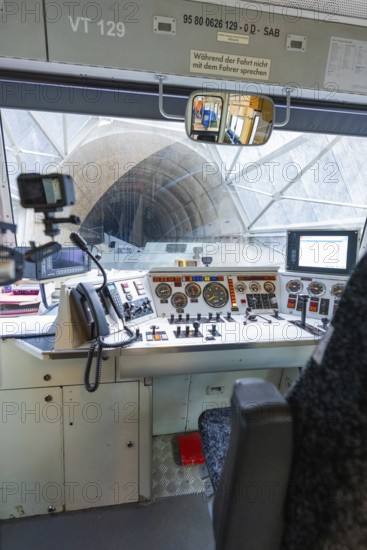 View of a tunnel from the train driver's cab, with technical equipment and control panel in the