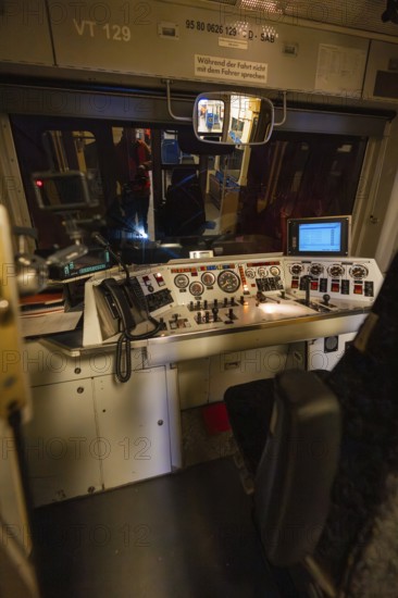 Driver's cab in the dark with illuminated control panel and technical controls, historic event,