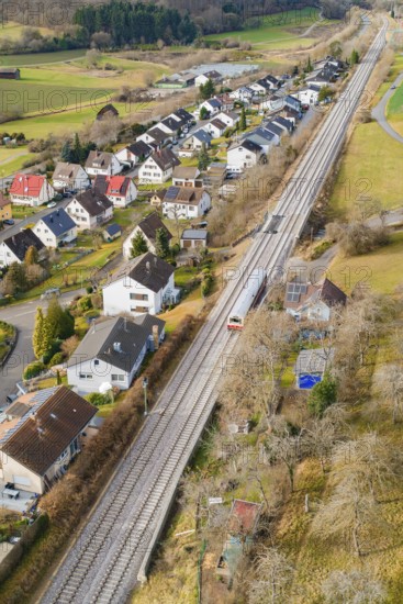 Rural area along railway tracks with houses and trees, historic event, first test run with a