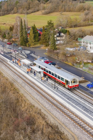 Train at the train station, surrounded by trees and small houses in a wintry landscape, historic