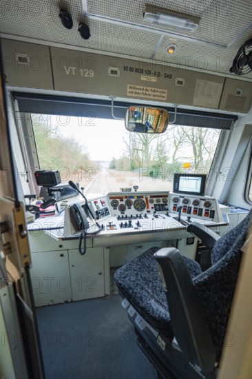 Driver's cab of a train with control elements and screens, view of tracks outside, historic event,