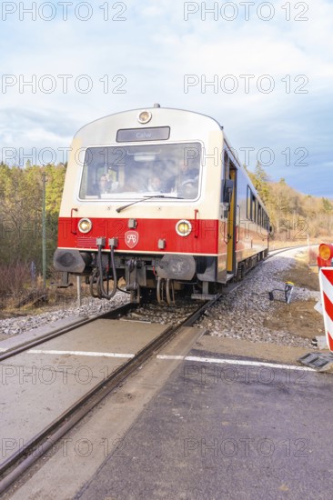 Train travels on rails through a landscape, past the railway signal, with cloudy sky, historic