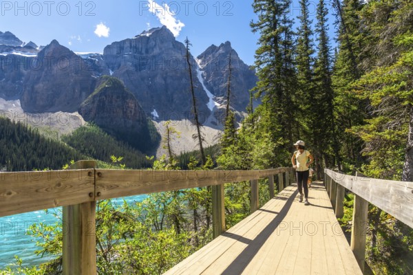 Female tourist walking on the rockpile trail admiring the turquoise color and the majestic