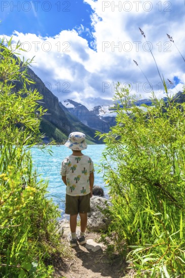 Young tourist admiring the stunning turquoise waters of lake louise, framed by victoria glacier and