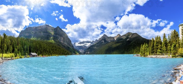 Panoramic view of tourists canoeing on turquoise lake louise, featuring the iconic fairmont chateau